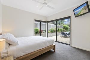 a bedroom with a bed and a sliding glass door at Stirling Escape in Metung