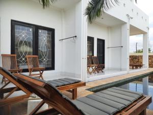 un patio con sillas y una piscina en Spear Villa, en Bumbang