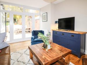 a living room with a tv and a coffee table at The Willows in Melton Mowbray