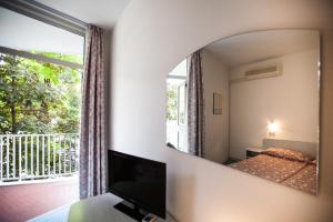 a mirror in a bedroom with a bed and a window at Hotel Park Spiaggia in Grado