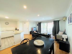 a living room with a table and a kitchen at Surfers Tradewinds in Gold Coast