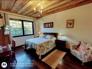 1 dormitorio con 1 cama y 1 silla en Tiradentes Pousada Ramalhete, en Tiradentes