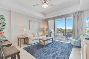 a living room with a couch and a table at The Wharf Condo with OASIS pool! in Orange Beach