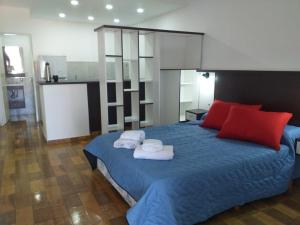 um quarto com uma cama azul com toalhas em Totoras Apart Federacion em Federación