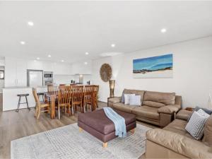 un soggiorno con un divano e un tavolo di Villa Serene 3, 6-10 Market Street - Surfside Apartments WiFi, water views, Air Con, Pool a Fingal Bay