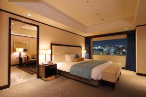a hotel room with a bed and a large window at ANA Crowne Plaza Okayama, an IHG Hotel in Okayama