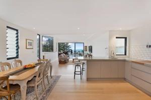 シドニーにあるBronte Beach House with Ocean Viewsのテーブルと椅子のあるキッチンとダイニングルーム
