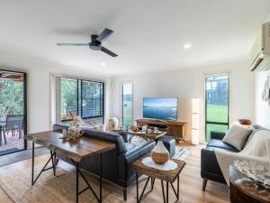 a living room with a couch and a table at Villa 121 Horizons in Salamander Bay