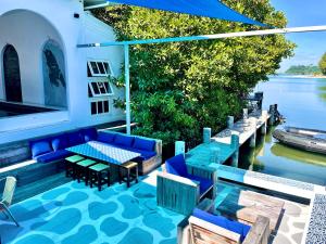 チャン島にあるWatercoloursの青い家具が備わるパティオ、水辺の景色を望む
