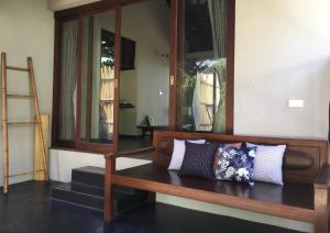 a room with a wooden bench with pillows on it at Jasmine & Tea House in Mae Nam