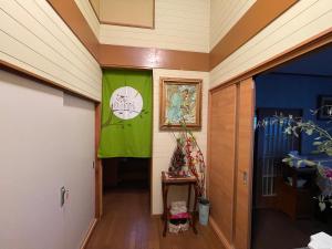un couloir avec une bannière verte sur le mur dans l'établissement 叶, à Nishikichō
