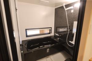 a bathroom with a black sink and a shower at Rinn Gion Kenninji Villa in Kyoto