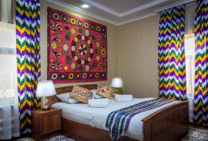 a bedroom with a bed with a colorful tapestry on the wall at Jahongir Guest House in Samarkand