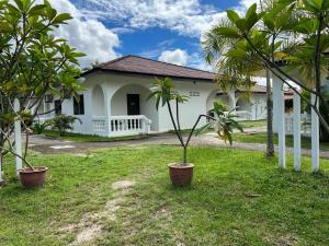 una casa con dos palmeras delante de ella en SANDY GARDEN RESORT LANGKAWI, en Pantai Cenang