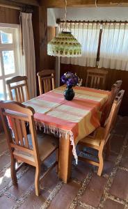 tavolo da pranzo con sedie e vaso di fiori di Cabaña Casa Coralillo Oaxaca a San Jerónimo Tlacochahuaya