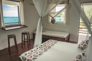 Chez Senga في Madirokely: غرفة نوم بسريرين وإطلالة على المحيط