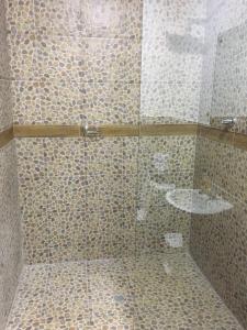 La salle de bains est pourvue d'une douche en verre et d'un lavabo. dans l'établissement Hospedaje El Girasol TABABELA, à Quito
