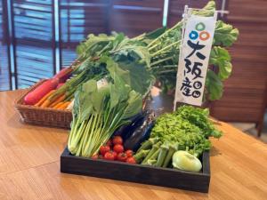 a tray of vegetables on a table with a basket of vegetables at Hiyori Hotel Osaka Namba Station in Osaka