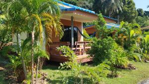 a wooden house with a porch in a garden at Alisa room for rent in Ko Chang