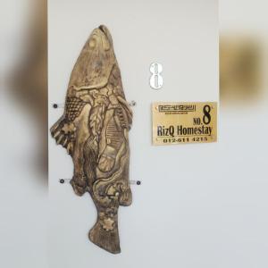a fossil of a fish with a sign on it at RizQ Homestay Tg Malim in Kerling