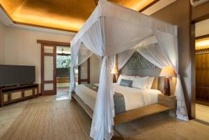 a bedroom with a bed with a canopy at Plataran Borobudur in Borobudur