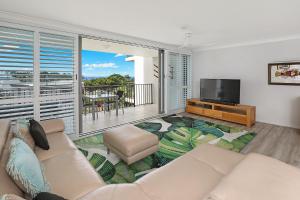 a living room with a couch and a flat screen tv at Majorca Isle Beachside Resort in Maroochydore