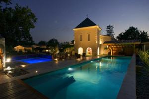 a large swimming pool in front of a building at Domaine de Larchey & son restaurant - Bordeaux Sud in Saint-Médard-dʼEyrans