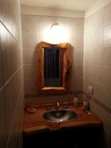 Baño con lavabo y espejo encima en Casa Vieja Estancia en Estancia Vieja