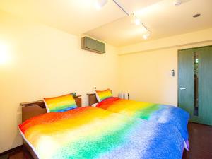 a bedroom with two beds with colorful sheets at 天弓イン Tenkyu Inn in Kachabaru