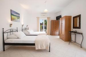 a bedroom with two beds and a table in it at Spacious Studios Lefkada Mountain View Near Beach in Dhráganon