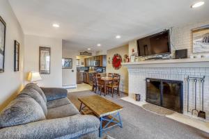 a living room with a couch and a fireplace at Sunrise Timberline I7 in Killington
