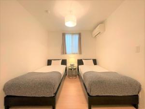 - 2 lits jumeaux dans une chambre avec fenêtre dans l'établissement Salon Shibuya - Vacation STAY 78188, à Tokyo