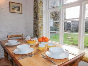 a wooden table with plates and bowls on top of it at The Coach House in Lifton