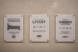 a couple of signs on a wall in a bathroom at Jeju Central Park Residence in Jeju