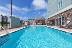 a swimming pool with blue water in front of a building at Holiday Inn Express & Suites Rockport - Bay View by IHG in Rockport