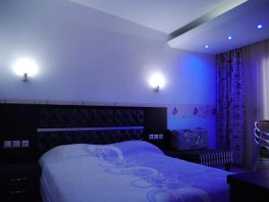 a bedroom with a large bed with purple lighting at Blue Bay Beach Hotel in Koinyra