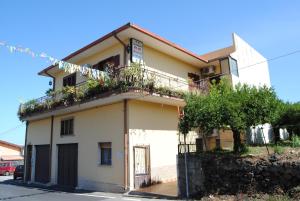 une maison avec un balcon fleuri dans l'établissement B&B Casa Paolo, à Fiumefreddo di Sicilia