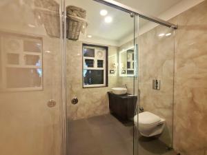 a bathroom with a shower and a toilet and a sink at RK RESORTS in kāraikāl +42 photos