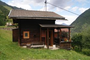 eine kleine Holzhütte auf einem Grasfeld in der Unterkunft Mühle in Görtschach in Sankt Veit in Defereggen