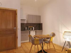 a kitchen with a table and chairs in a room at Centre Confolens studios rénovés in Confolens