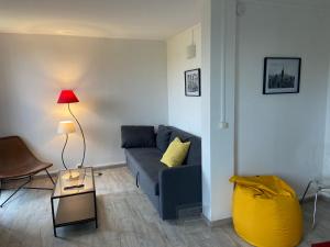 ein Wohnzimmer mit einem blauen Sofa und einer Lampe in der Unterkunft Au Saint-Hubert, Appartement 3 chambres Valenton in Valenton