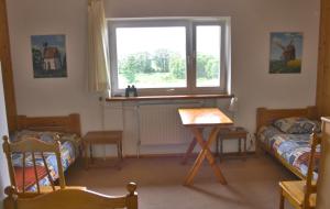 a room with two beds and a window and a table at Dom pod Czarnym Bocianem in Tykocin