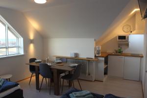 a kitchen with a table and chairs in a room at Guesthouse Hateigi 2 in Hella