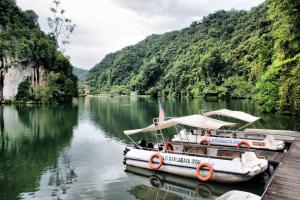 two boats docked at a dock on a river at The Brownstone Hostel & Space in Ipoh +35 photos