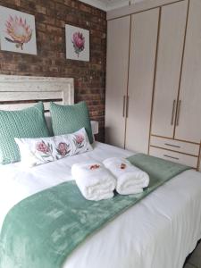 ein Schlafzimmer mit einem Bett mit Handtüchern darauf in der Unterkunft The Honeycomb in Kimberley