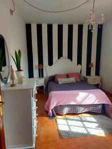 um quarto com uma cama e uma parede listrada a preto e branco em Casa Elsa em Puerto del Rosario