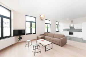 Smartflats Design - Opera في لييج: غرفة معيشة مع أريكة وطاولة