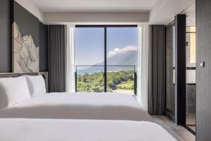 Rúm í herbergi á The Moment Hotel Hualien by Lakeshore
