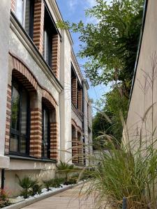 a building with windows and plants on the side of it at Maison d'hotes L'atelier du Charmois in Vandoeuvre-lès-Nancy
