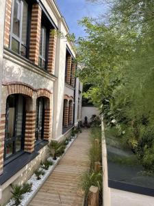 una pasarela de madera frente a un edificio en Maison d'hotes L'atelier du Charmois en Vandoeuvre-lès-Nancy